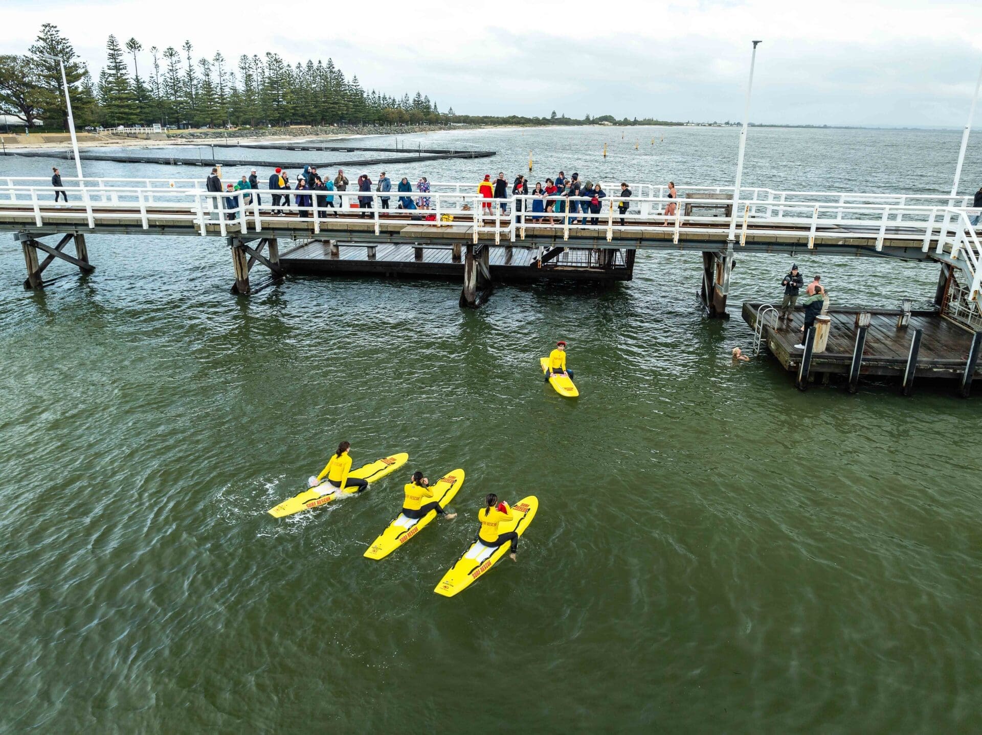 People Standing On The Edge Of Busselton Jetty And Jumping Into The Water.