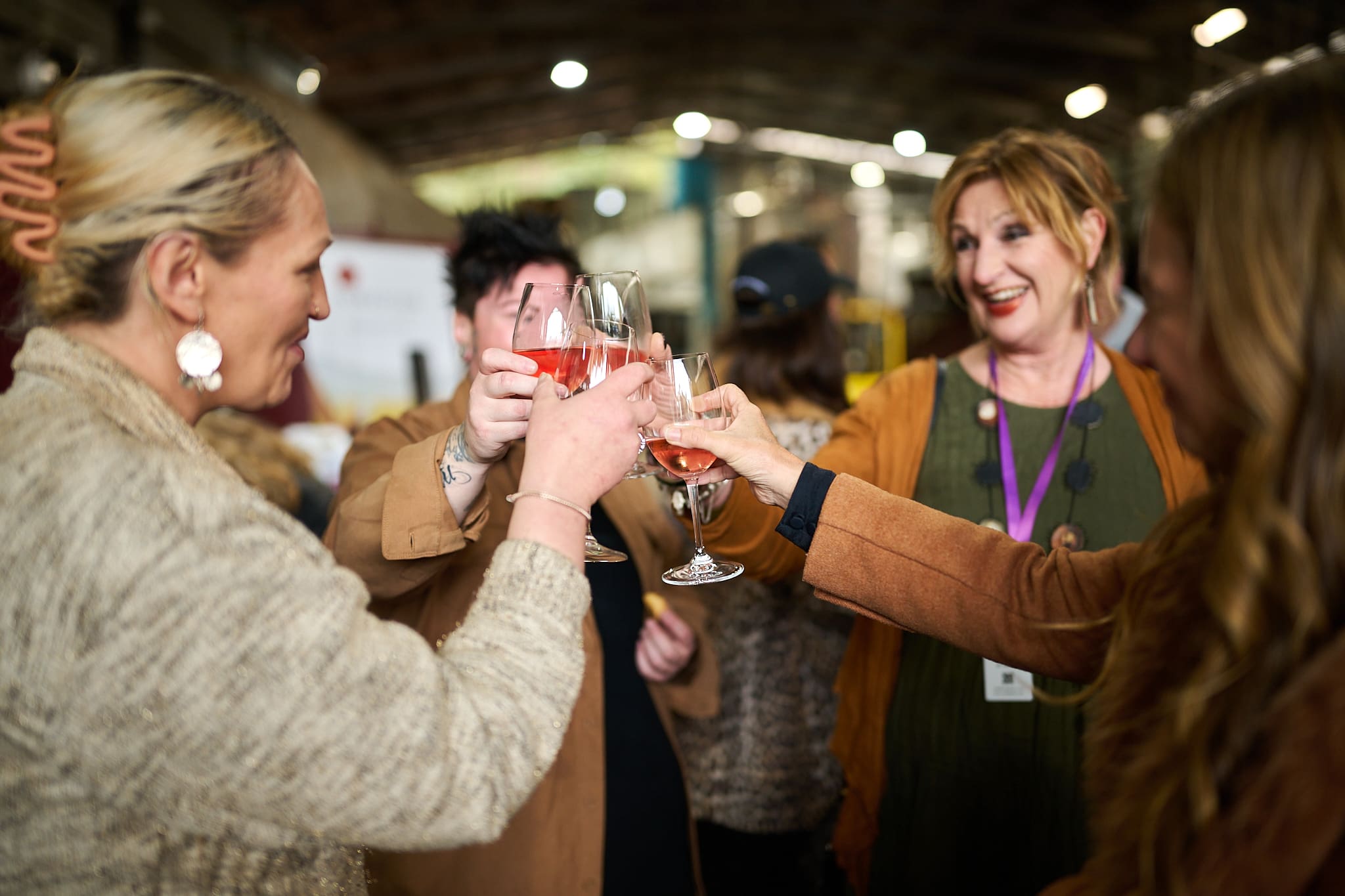 Group Of Women Clinking Wine Glasses Together And Smiling.